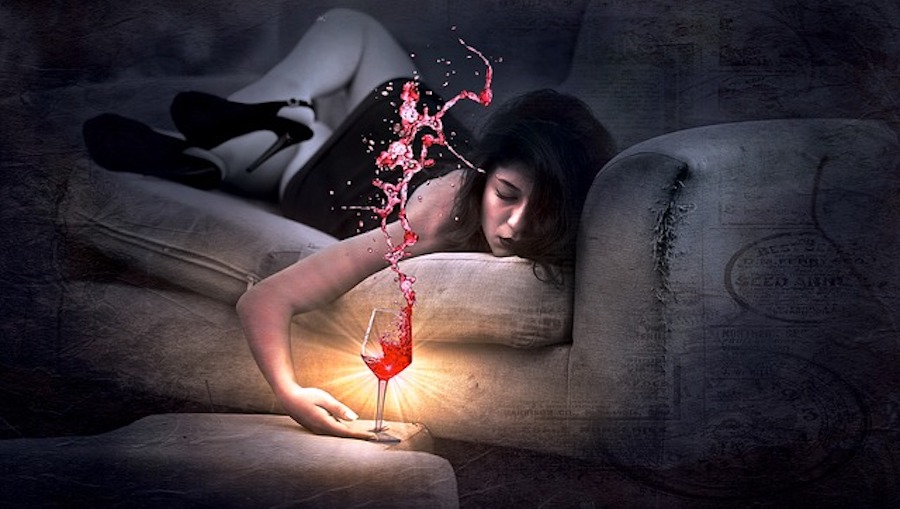 woman on sofa drinking red wine