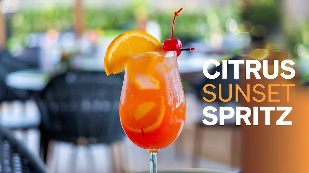 Citrus Sunset Spritz mocktail garnished with an orange slice in a glass on a table