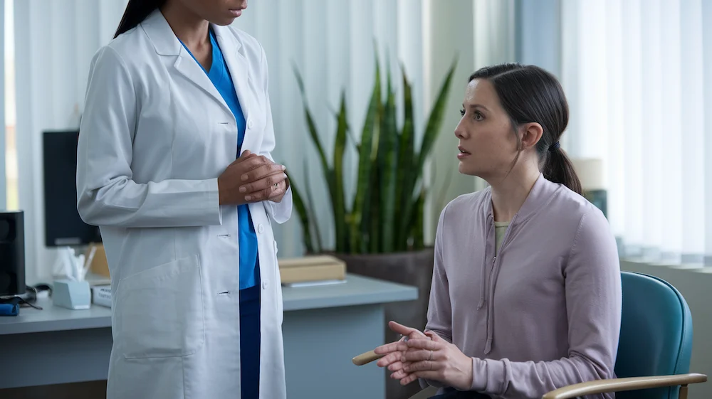 Female patient talking with her doctor, at the doctor's office